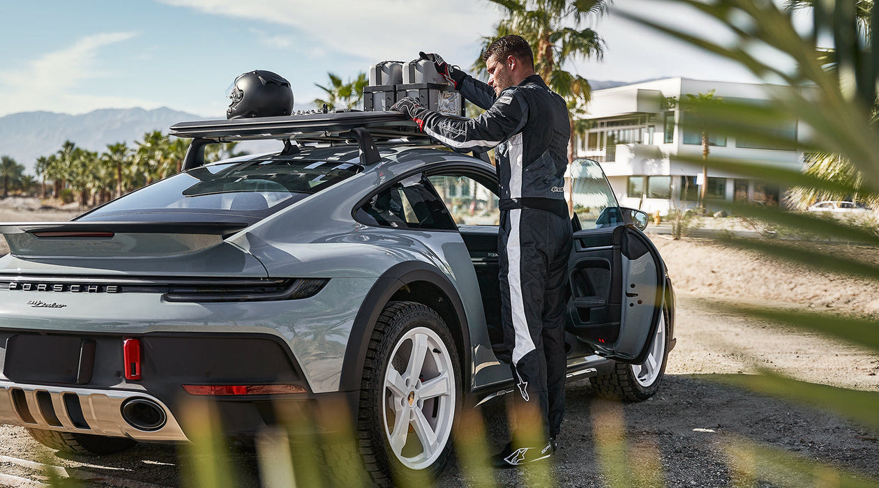 Driver reading Alpinestars GP Pro Comp Racing Suit and a Porsche Car - Fast Racer